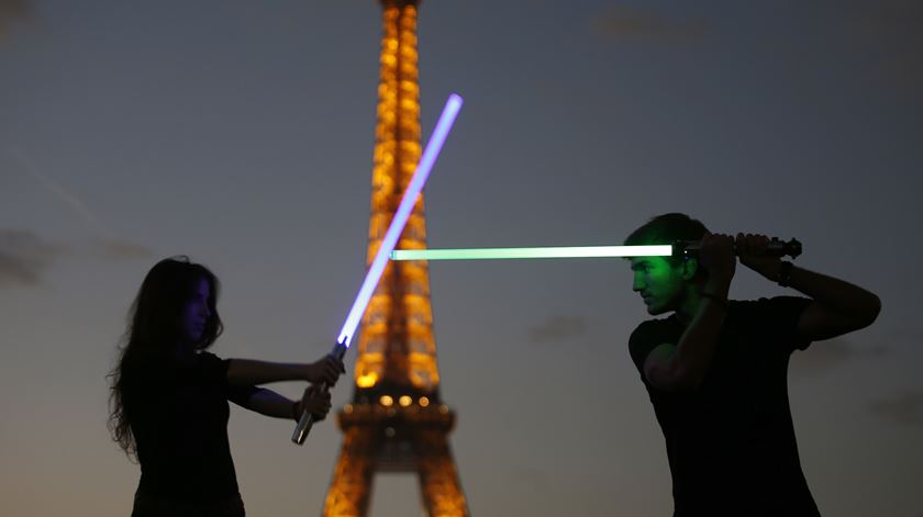 Membros da Sport Saber League posam em frente à Torre Efiffel com os seus sabres de luz. Foto: Charles Platiau/Reuters