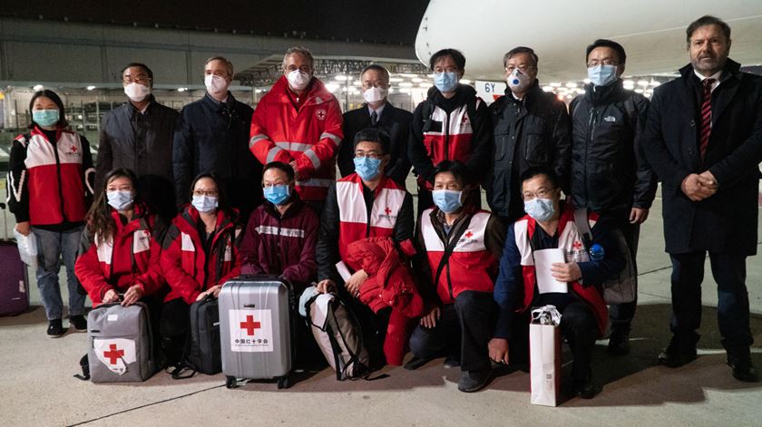 Médicos chineses com autoridades de saúde italianas no aeroporto. Foto: Cruz Vermelha Italiana/EPA