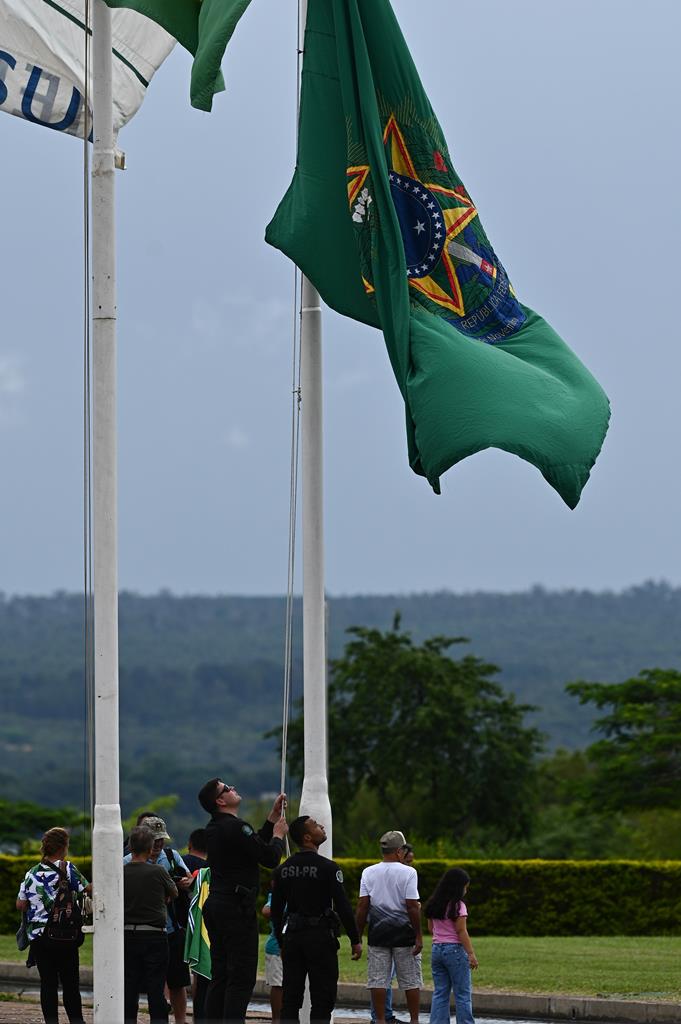 Segurança do Palácio da Alvorada, a residência presidencial brasileira, removem bandeira após partida de Jair Bolsonaro para os EUA. Foto: André Borges/EPA