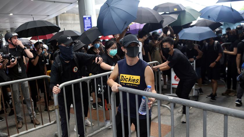 Manifestantes colocam barricadas para bloquear acessos ao aeroporto de Hong Kong. Foto: Jerome Favre/EPA