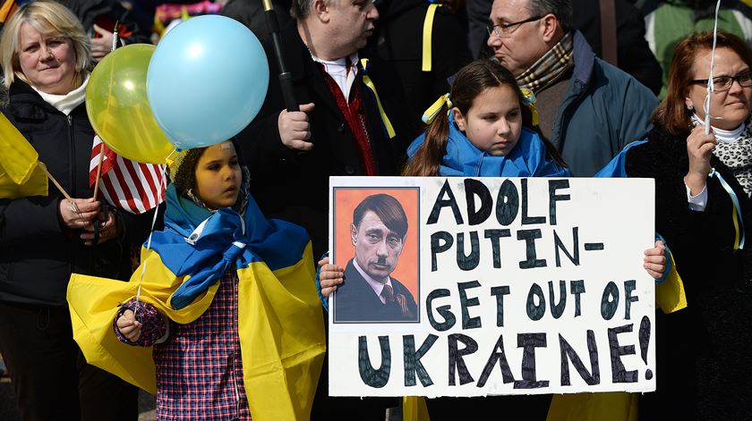 Jovem mostra um cartaz contra Vladimir Putin, numa manifestação pacífica em oposição à anexação da Crimeia, em 2014. Foto: Reuters