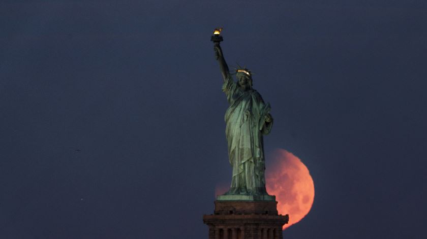 "Super Lua Azul de Sangue" vista atrás da estátua da Liberdade, em Nova Iorque. Foto: Justin Lane/EPA