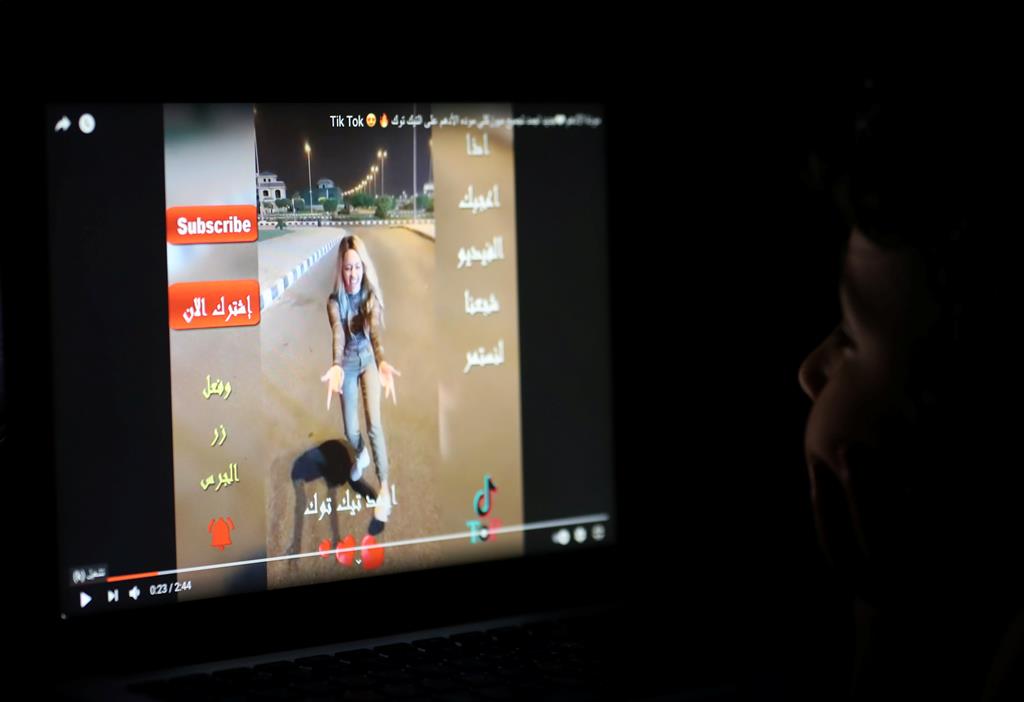 Criança vê ecrã de computador onde aparece a rede social TikTok Foto: Reuters
