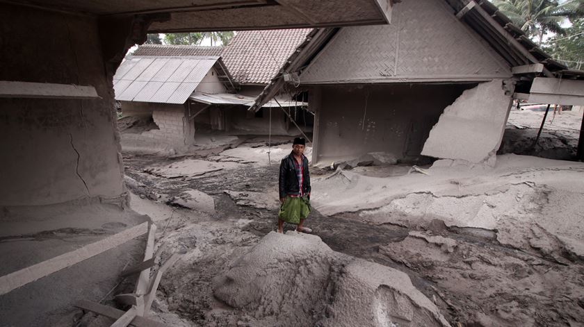 Homem junto à sua casa destruída pela lava e cinzas do vulcão. Foto: Ammar/EPA